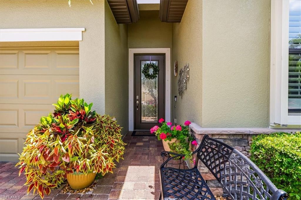 Stucco exterior featuring a covered entry and a paneled garage door