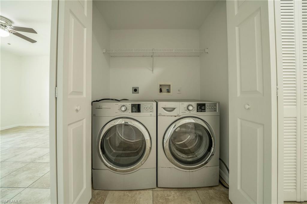 Laundry area with light tile patterned floors, washing machine and dryer, and ceiling fan