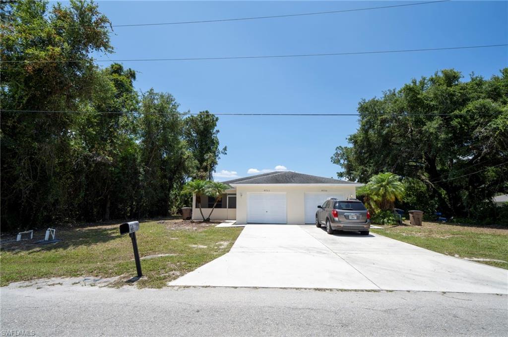 Single story home featuring concrete driveway, a front yard, a garage, and stucco siding