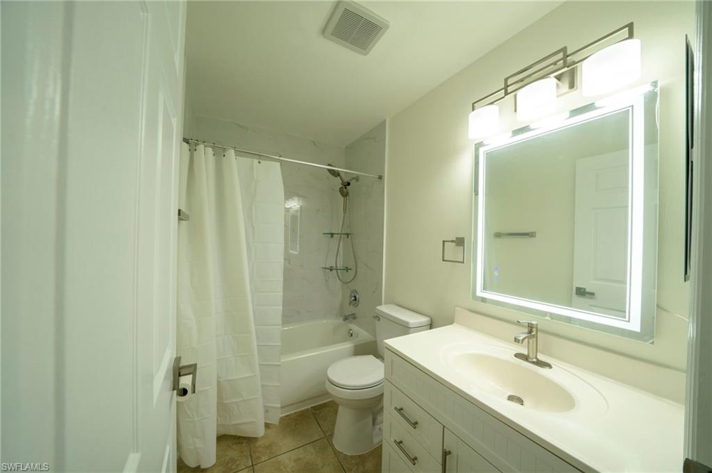Bathroom featuring vanity, tile patterned flooring, and shower / tub combo