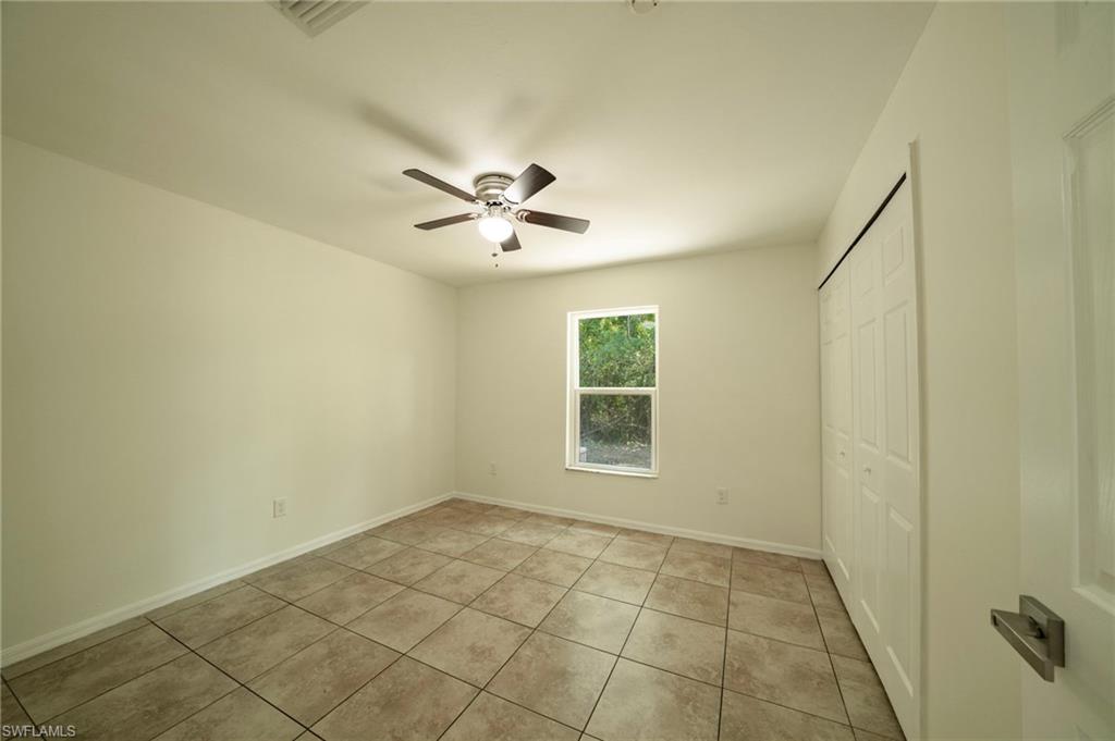 Unfurnished bedroom with a closet, light tile patterned floors, and ceiling fan
