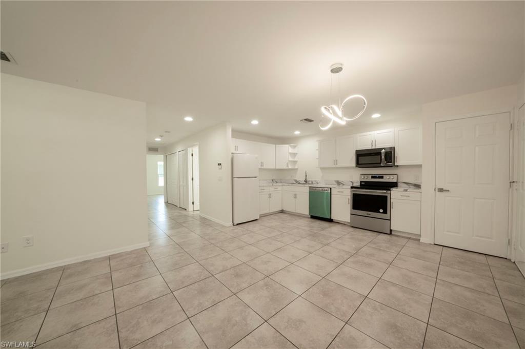 Kitchen featuring a chandelier, appliances with stainless steel finishes, light countertops, white cabinets, and recessed lighting