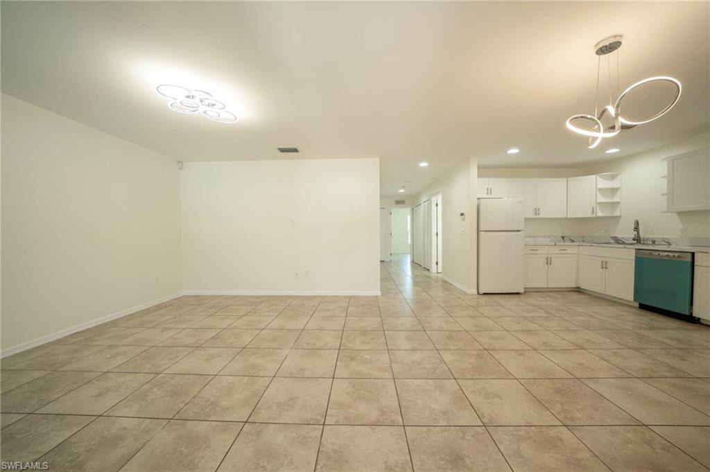 Kitchen featuring open shelves, freestanding refrigerator, dishwashing machine, recessed lighting, and white cabinetry