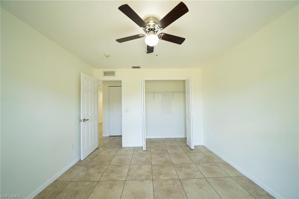 Unfurnished bedroom featuring light tile patterned floors, a ceiling fan, and a closet