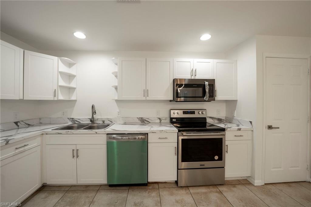 Kitchen featuring stainless steel appliances, open shelves, white cabinetry, recessed lighting, and light tile patterned floors