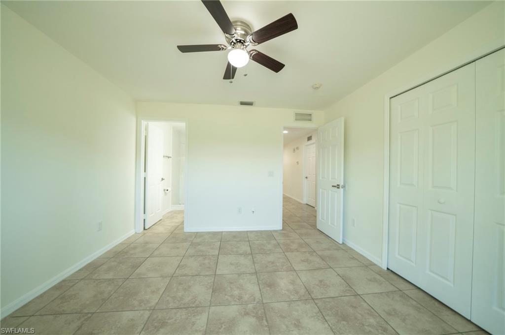 Unfurnished bedroom featuring light tile patterned floors and a ceiling fan