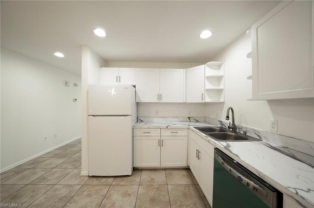 Kitchen featuring freestanding refrigerator, dishwashing machine, recessed lighting, open shelves, and white cabinetry