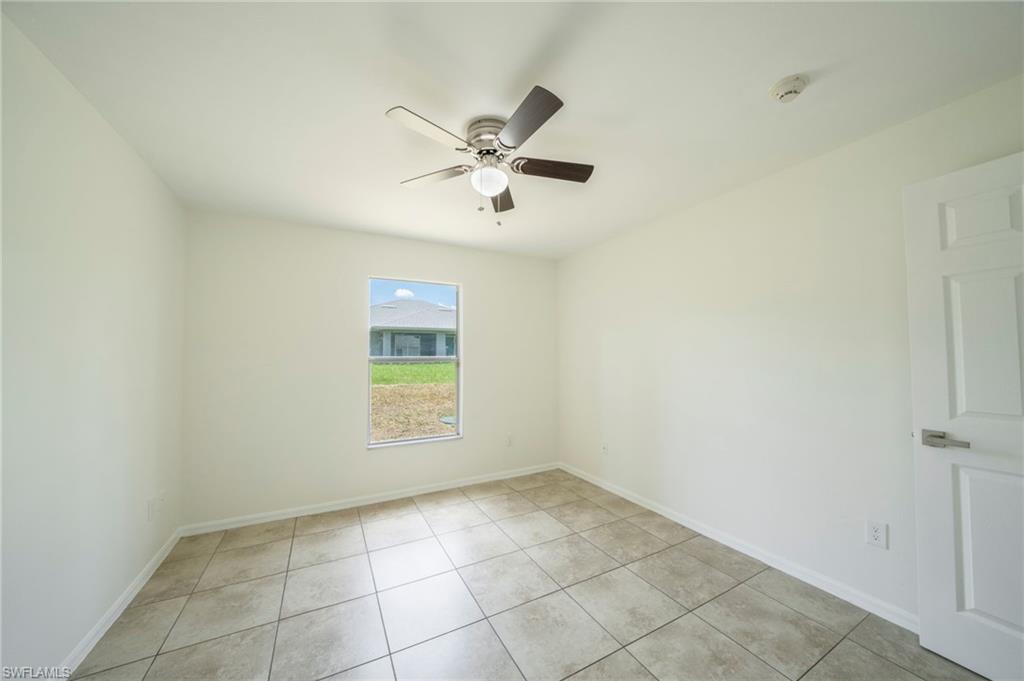 Spare room with ceiling fan and light tile patterned flooring