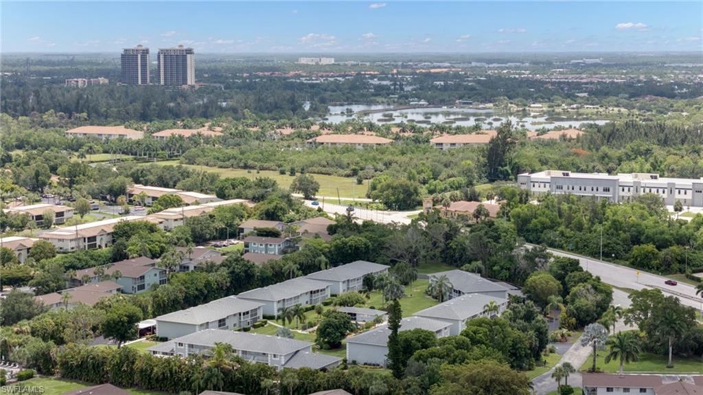 Expansive aerial perspective showcasing a developed community with abundant mature trees and natural landscaping