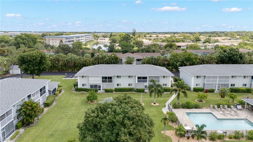 Multi-story residential buildings featuring screened lanais, surrounded by mature landscaping and green spaces