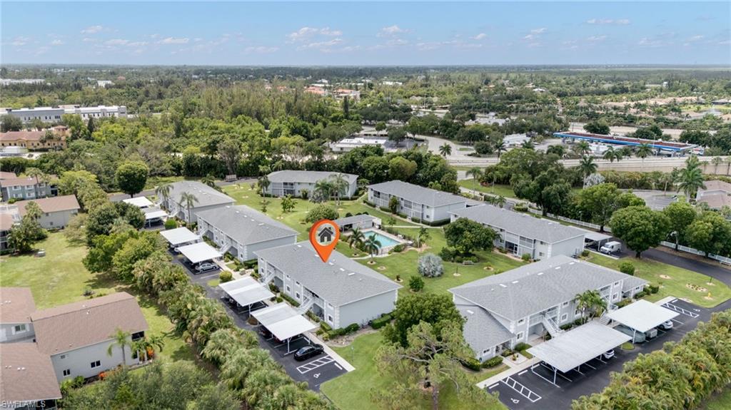 Aerial perspective showcasing multiple residential buildings with uniformly pitched roofs and carports