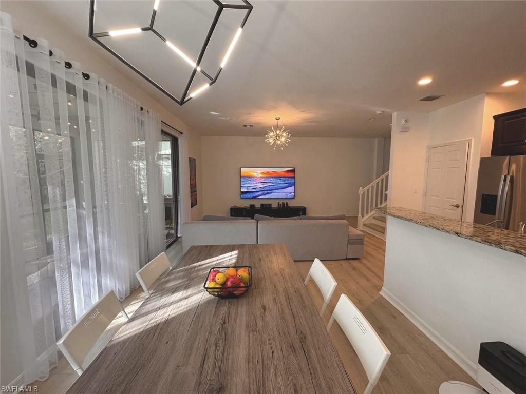 Dining room featuring a chandelier, light wood-style floors, stairs, and recessed lighting
