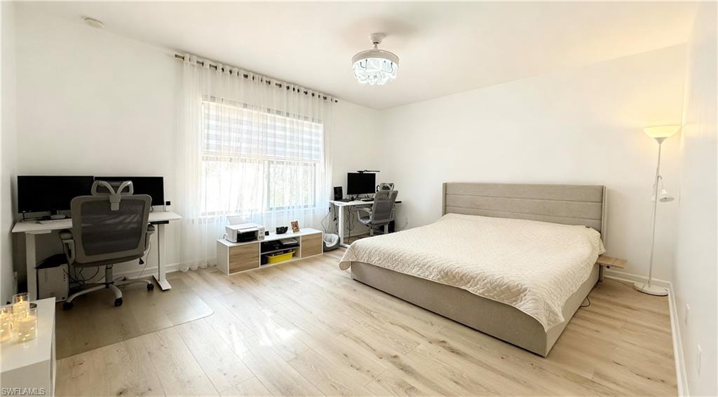 Bedroom featuring an office area and wood finished floors