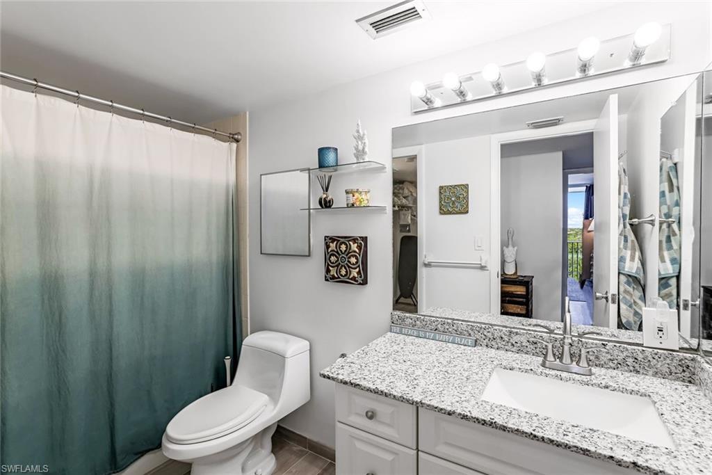Bathroom with vanity with granite countertop and ample cabinet space.