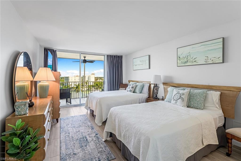 Bedroom with two full-sized beds and sliding glass doors opening to lanai.