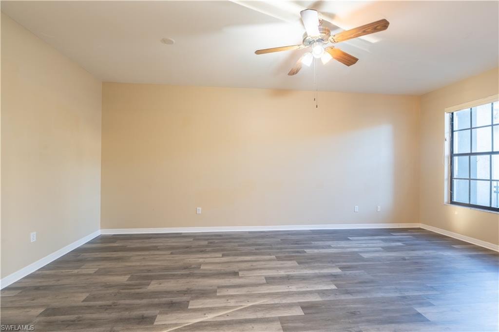Spare room with ceiling fan and dark wood-type flooring