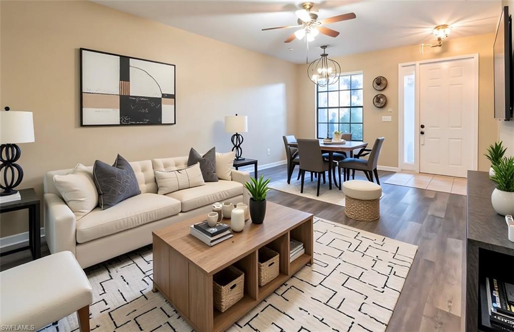 Living room featuring light wood finished floors, a ceiling fan, and hanging lights