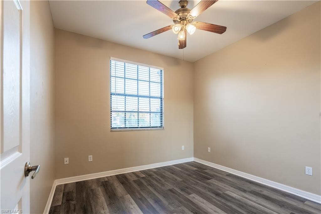 Spare room with dark wood-style flooring and ceiling fan