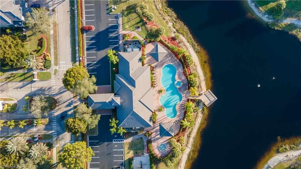 Drone / aerial view of a pool area and a large body of water