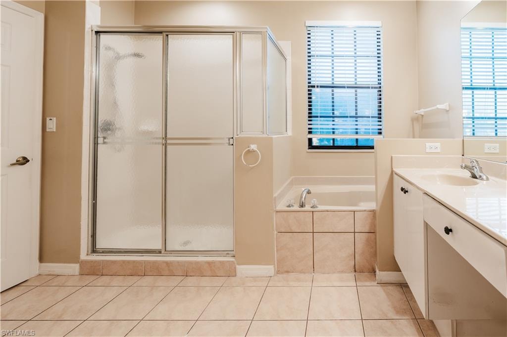 Bathroom with vanity, a shower stall, a bath, and light tile patterned flooring