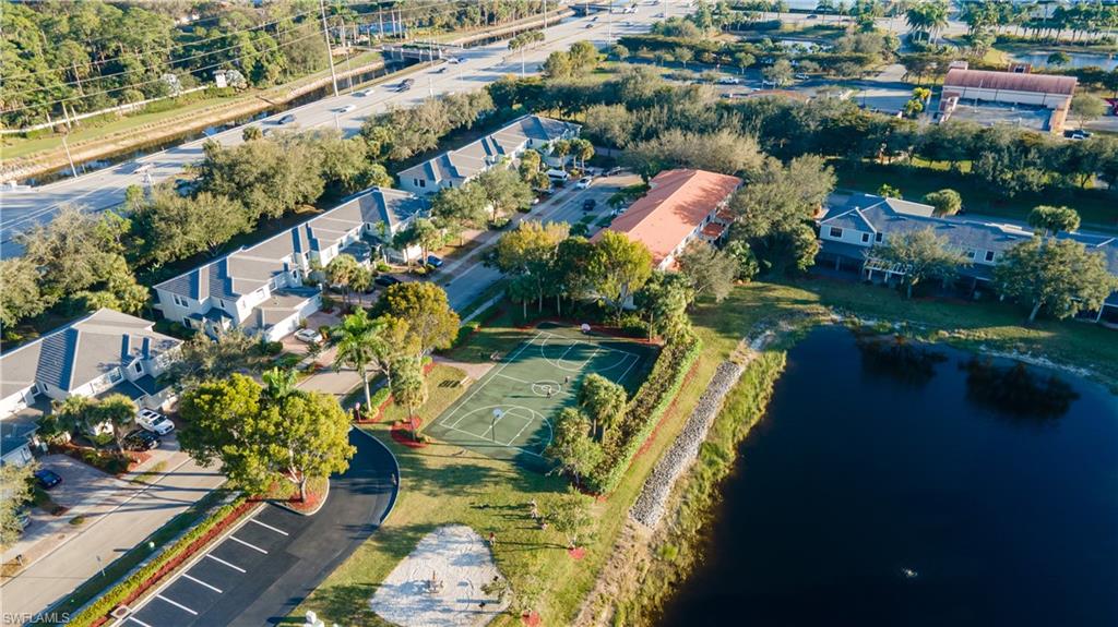 Aerial view of property and surrounding area featuring a nearby body of water and nearby suburban area