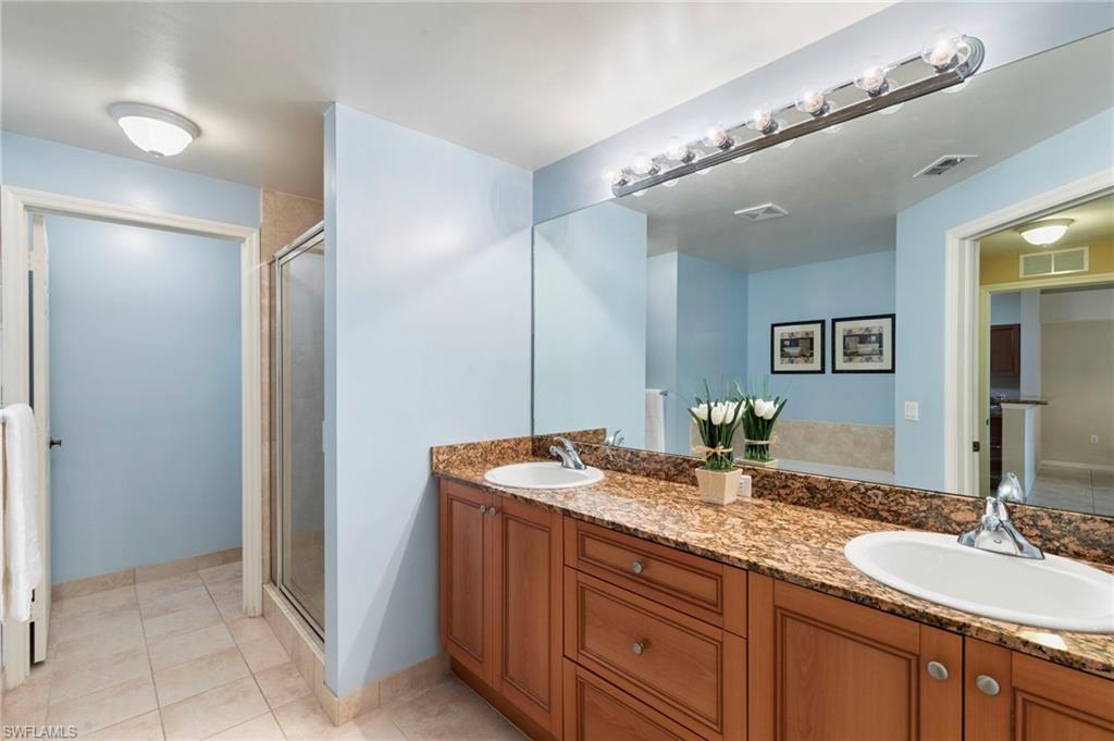 Primary ensuite bath with dual sinks, walk in shower, garden tub, and water closet.