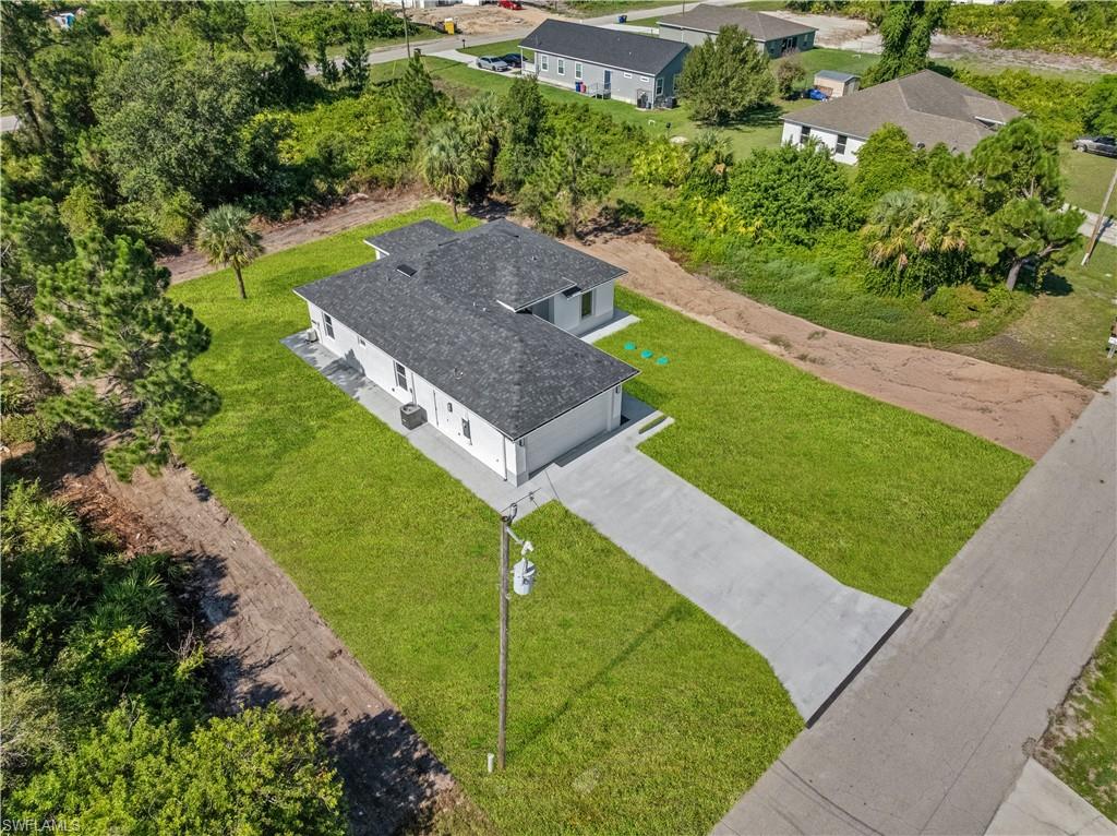Modern single-story residence with a dark shingle roof and a light-colored exterior