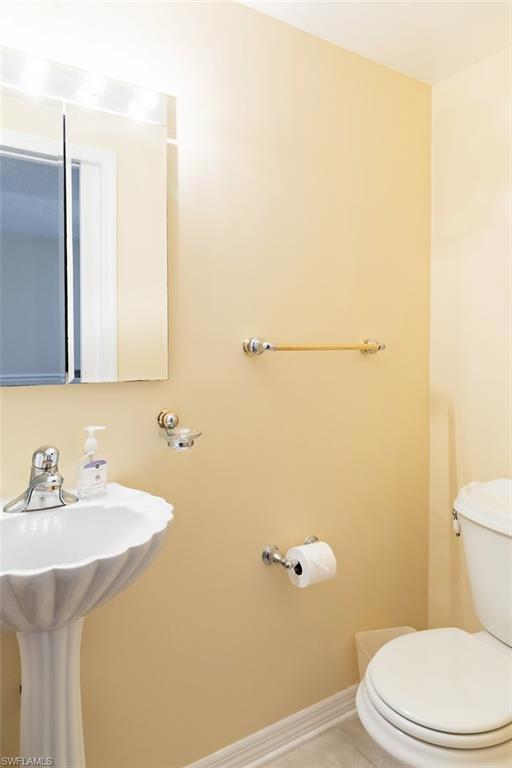 Half bathroom with toilet and tile patterned floors