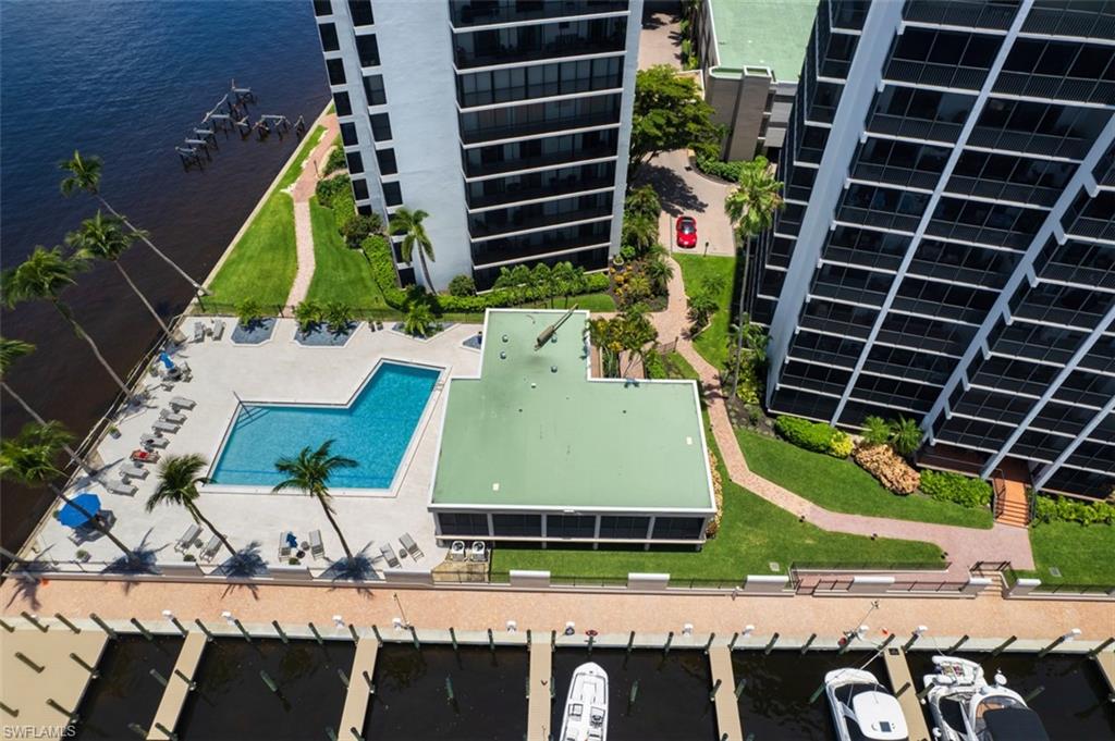 Drone / aerial view of a pool area and a large body of water
