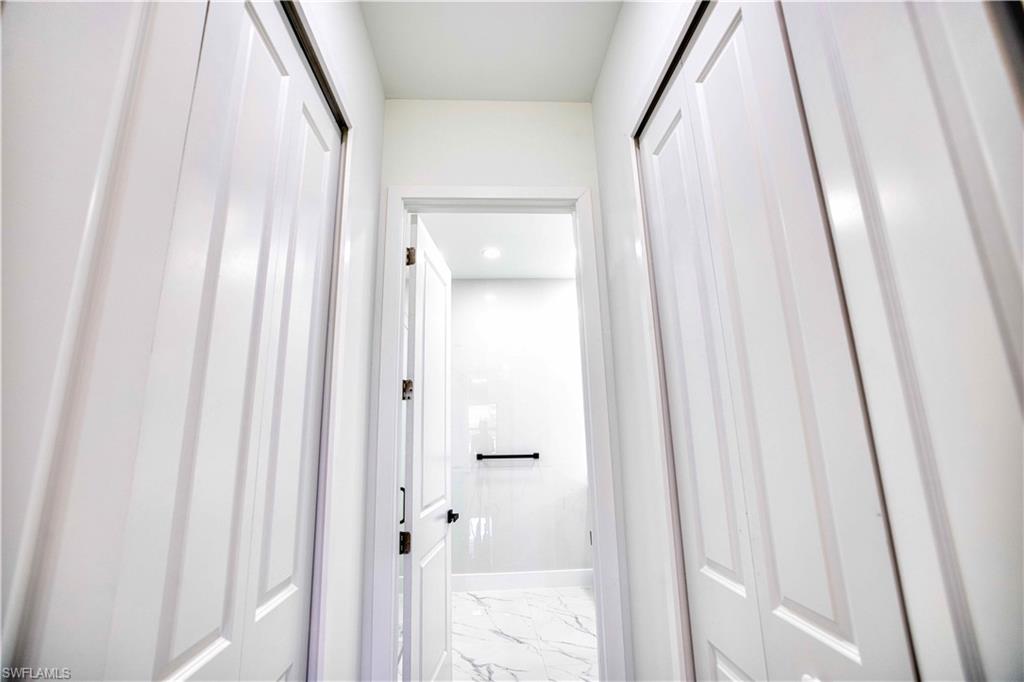 White paneled bifold closet doors framing a hallway entrance to a bathroom