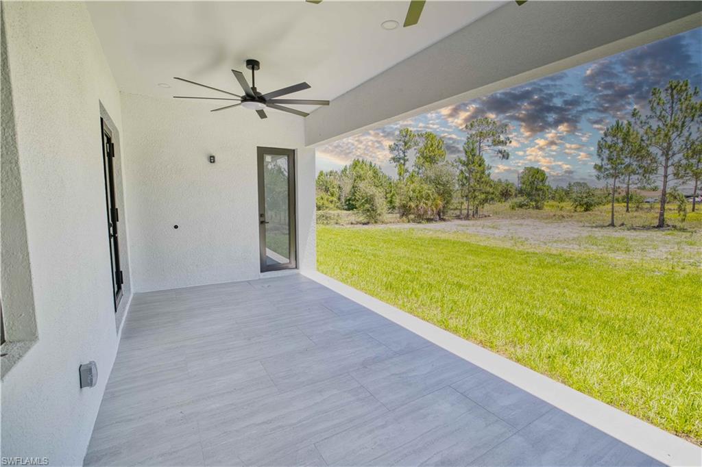 Expansive covered patio featuring light-toned tile flooring and a modern ceiling fan
