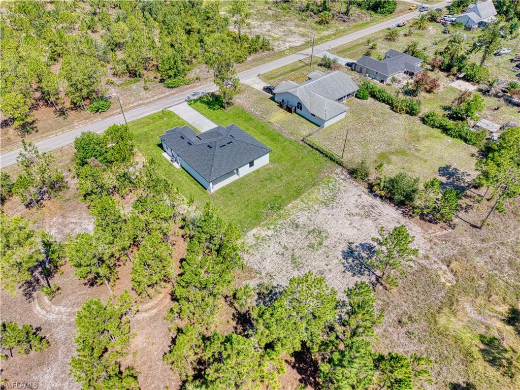 Newly constructed residence featuring a dark shingle roof and a concrete driveway