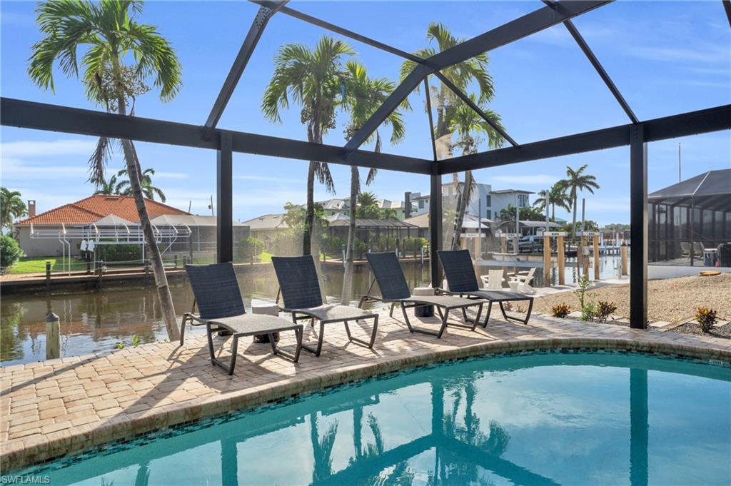 Relax around the spacious pool area and enjoy the view of the gulf access canal and blue skies - Digitally Enhanced