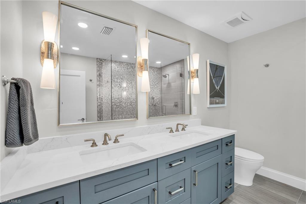 Primary Bathroom with dual sinks and designer touches like the mirrors and light fixtures