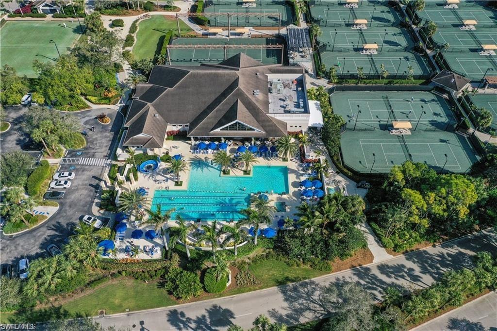 Expansive clubhouse featuring a large swimming pool, an adjacent lap pool, and multiple tennis courts