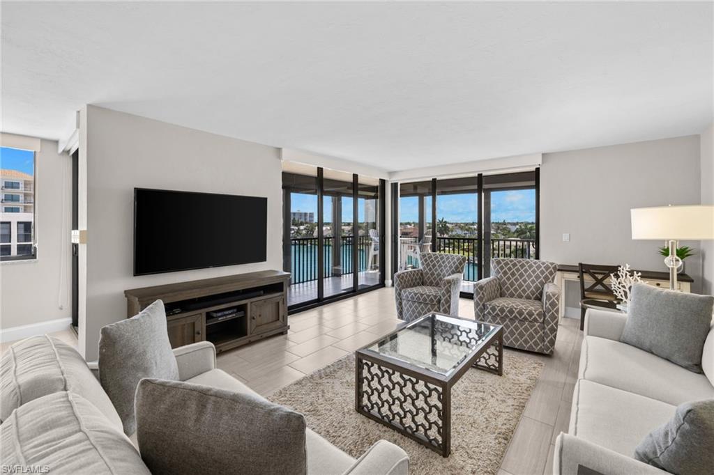 Spacious living area featuring large format tile flooring and extensive sliding glass doors