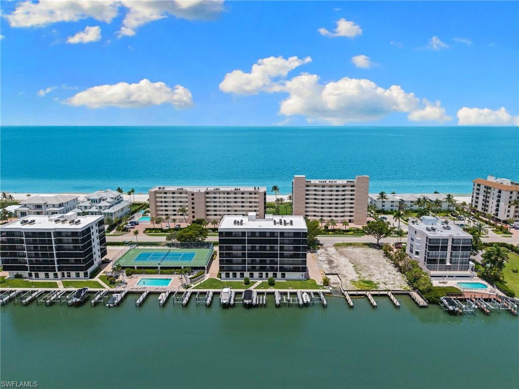 Waterfront multi-story buildings with balconies, featuring direct access to boat slips and a swimming pool
