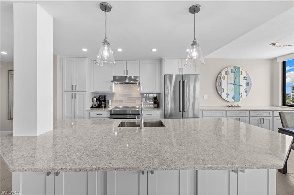 Spacious kitchen island featuring a light-toned countertop with integrated sink and modern fixtures