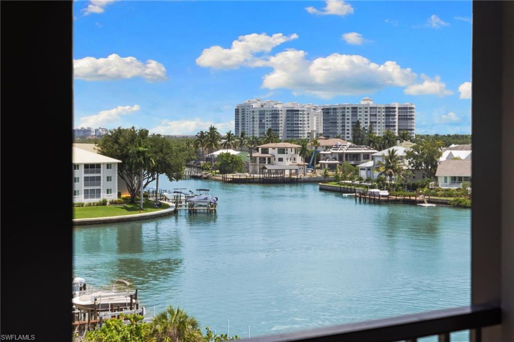 Expansive waterfront views featuring a wide canal, private docks, and distant high-rise buildings