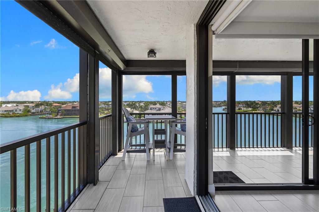 Outdoor balcony featuring light-toned tile flooring and dark metal railings