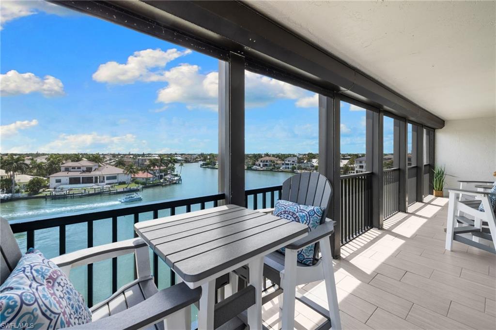 Waterfront balcony featuring expansive canal scenery, tile flooring, and a contemporary railing design