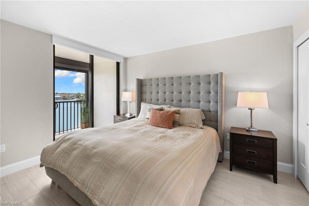 Bedroom featuring a sliding glass door to a balcony overlooking a body of water