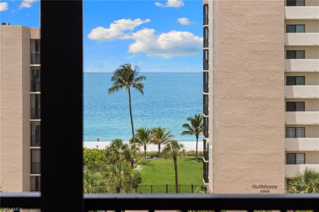 Expansive water frontage with white sand beach and verdant lawn