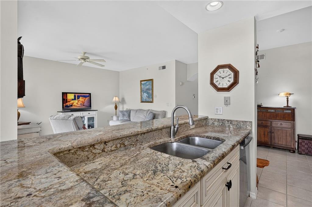 Kitchen island with a double stainless steel sink and a gooseneck faucet, set within a granite countertop