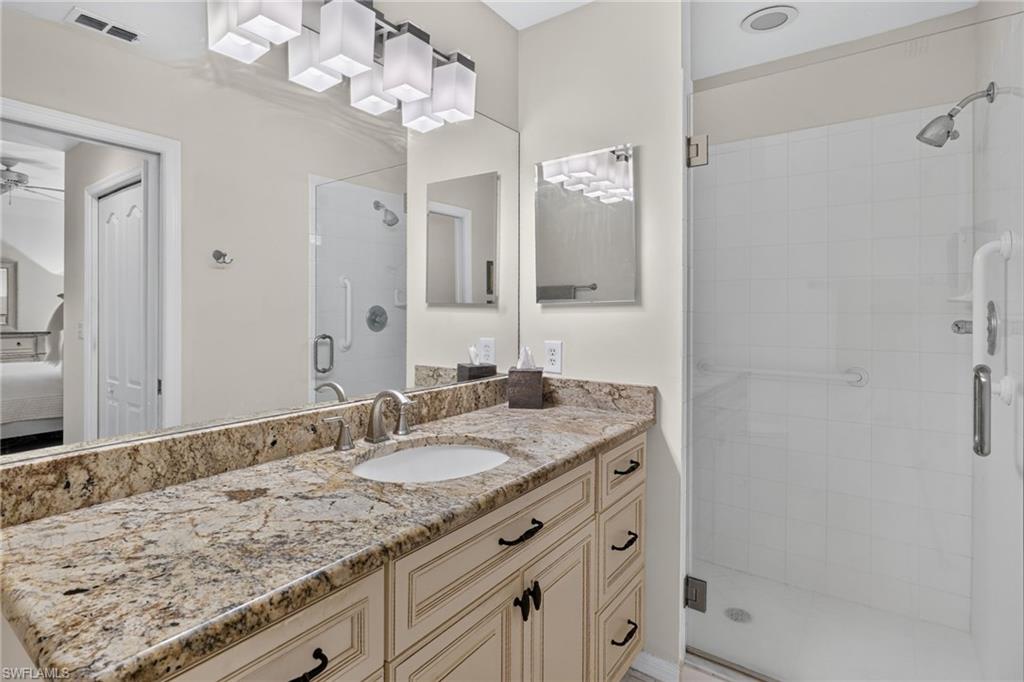 Bathroom vanity with a light-toned, speckled countertop, an undermount sink, and brushed nickel faucet