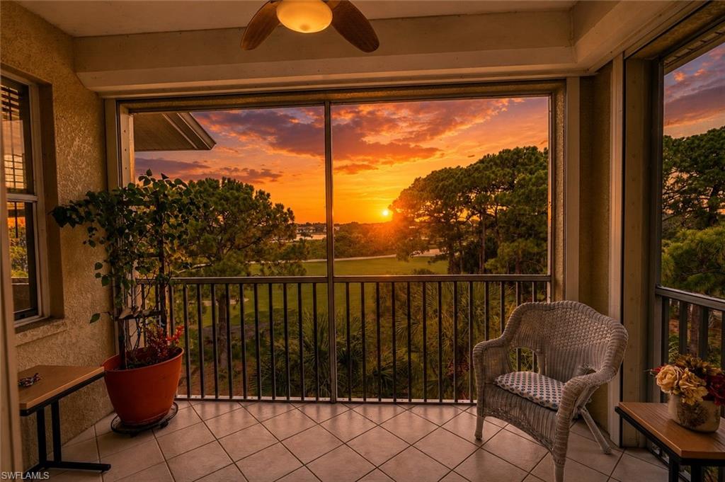 Screened balcony featuring tiled flooring, a ceiling fan, and a metal railing