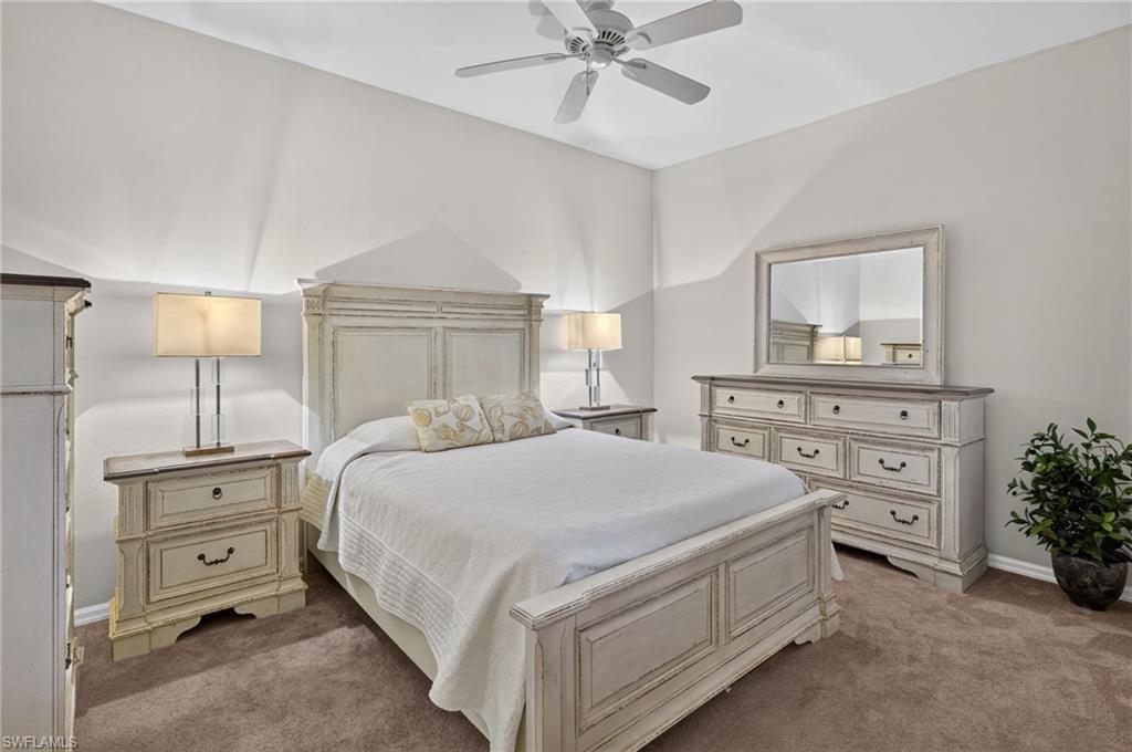 Recessed lighting and ceiling fan complement the neutral wall tones and brown carpeting