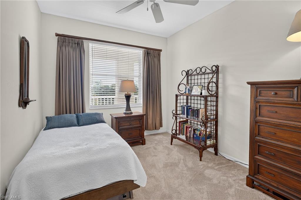 Carpeted room featuring a ceiling fan, a window with blinds and drapes, and neutral wall paint