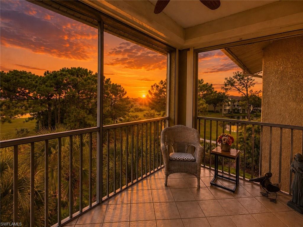 Screened balcony with tiled flooring, metal railings, and a ceiling fan