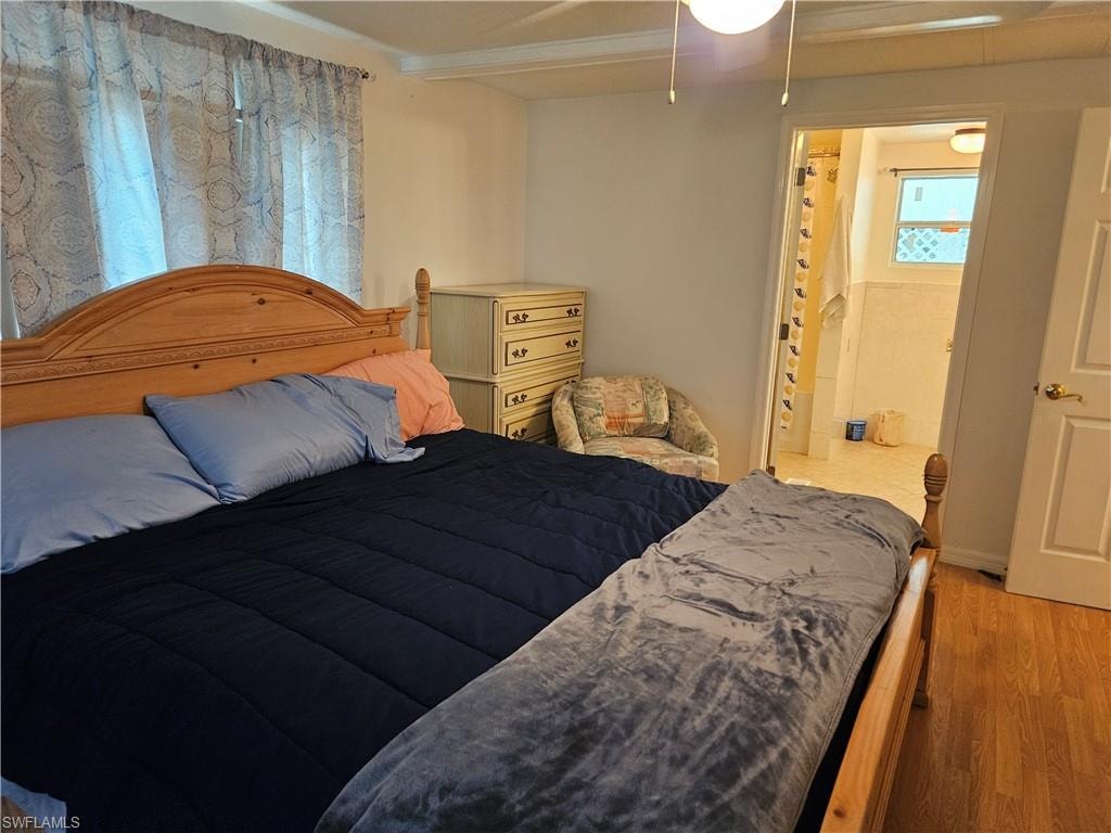 Bedroom featuring ensuite bathroom and light hardwood / wood-style flooring